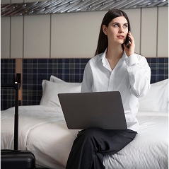 Woman working on laptop in comfortable hotel room